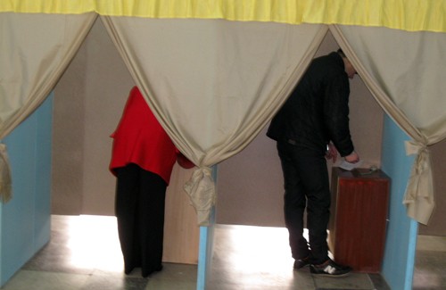 Члены комиссии следят за тем, что происходит в кабинках для голосования