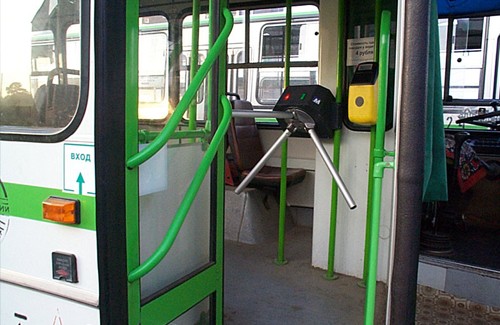 Передняя дверь автобуса, оборудованная турникетом и валидатором