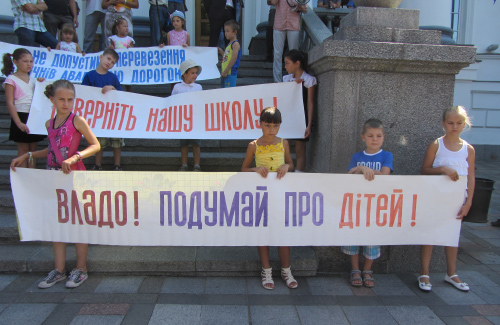 Дети держут плакаты против закрытия школы