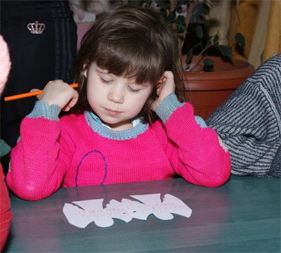 Діти пишуть на листочку у вигляді янгола, що хочуть отримати на Новий рік
