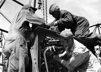 Сержант John M. Bassett, Леонид Бойков, сержант Michael Cajolda обслуживают двигатель американского тяжелого бомбардировщика Б-17 «Летающая крепость». 169-я авиабаза