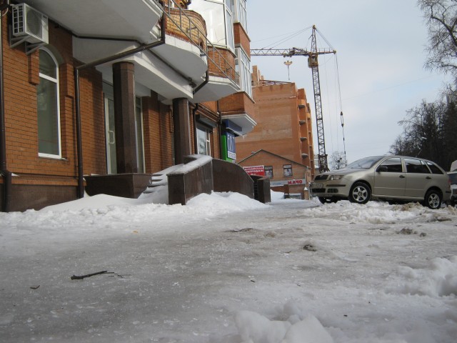 Тротуар возле дома покрыт ледяными осколками