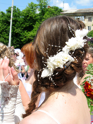 В свадебных прическах часто используются традиционные искусственные цветы. Попробуйте заменить их бутоньерками