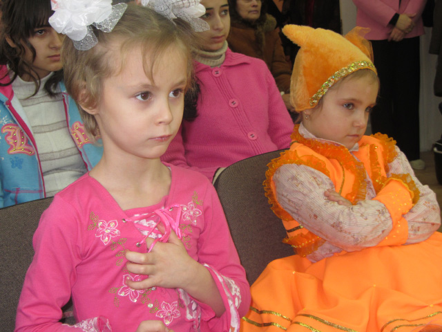 Девочка-красавица и Лисичка наслаждаются выступлением детей