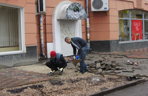 Робітники відновлюють плитку біля магазину