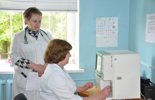 Ольга Гиря з працівником лікарні біля апарату