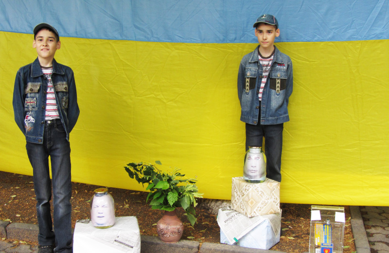 Діти фотографуються на фоні жовто-синього стягу та 3D голів Путіна і Януковича