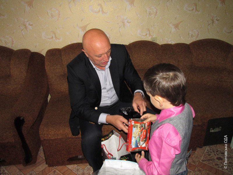 Валерій Головко допомагає маленькому Ярославу діставати подарунки