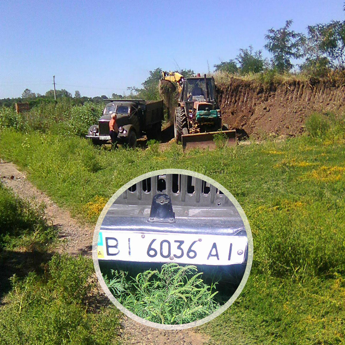 На території КП «Декоративні культури» трактор комунальників навантажує приватну вантажівку чорноземом