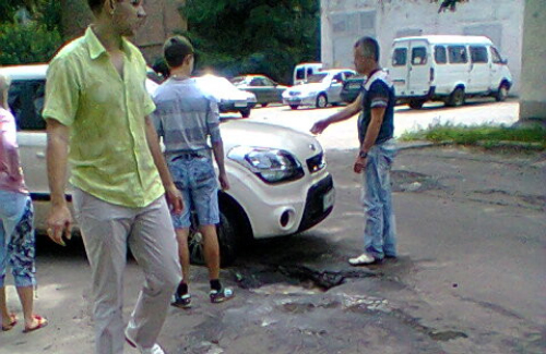Автомобиль попал колесом в яму на дороге