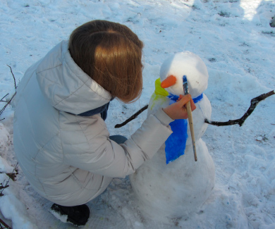 Дівчина розмальовує снігову «євробабу»