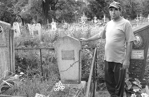 Доглядач кладовища в Миргороді Василь Колісник показує могилу, на якій підлітки вивернули плиту