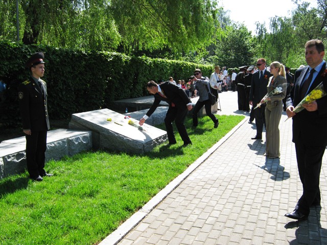 Городской голова Полтавы Андрей Матковский кладет цветок на плиту с именами погибших