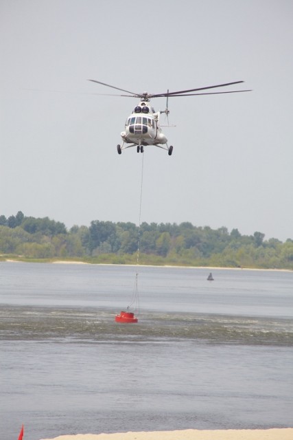 Вертоліт опустився і завис над річкою, набирає воду із Дніпра, щоб гасити пожежу