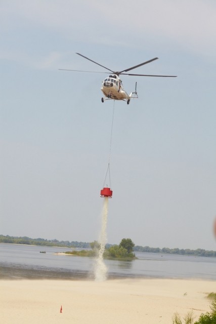 Вертоліт викидає воду на осередок вогнища