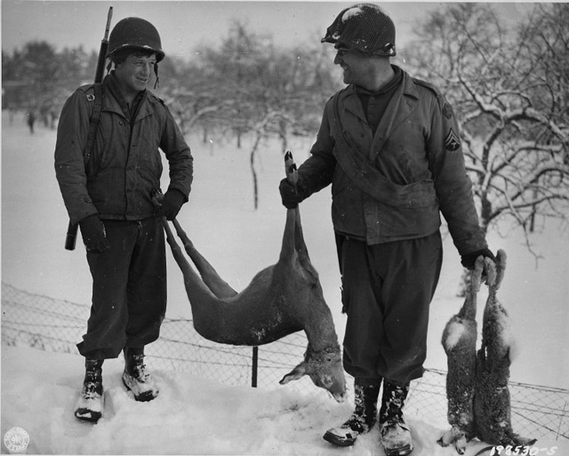 Рядовой Клинтон Калверт  и капрал Рой Свишер возвращаются с добычей после охоты. Бельгия, 1945 г.