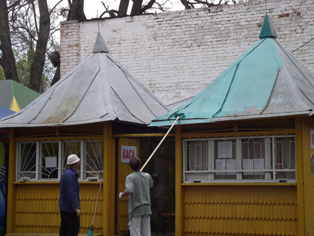 Робітники фарбують дах каси