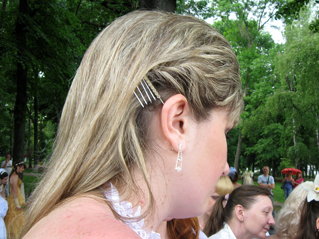 Много мелких заколок, фиксирующих волосы возле ушей, — свежий вариант для каскадной стрижки на волосах средней длинны