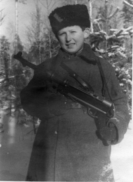 Советский подросток-партизан Коля Любичев с трофейным пистолет-пулеметом МР-38 в зимнем лесу
