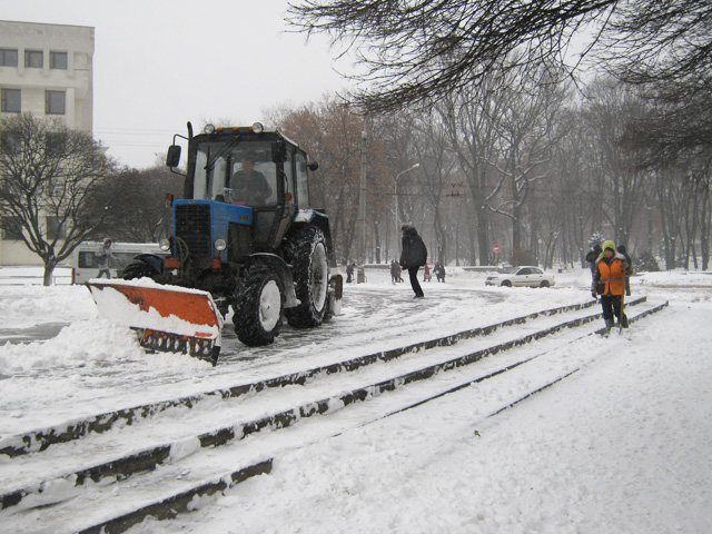Машина і людина розчищають сніг разом (біля пам’ятника Леніну)