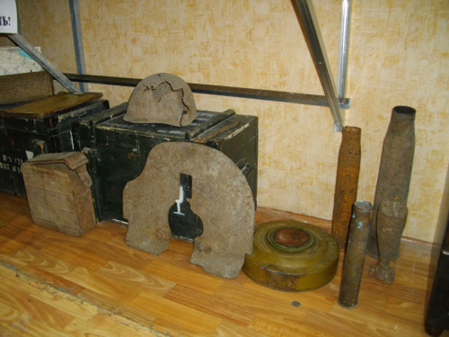 Реальные исторические артефакты: щиток от пулемёта «Максим», снарядные гильзы и миномётный выстрел.