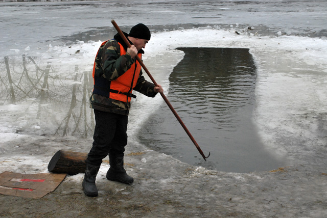 МНСівці розбиваьть ковзкий лід, щоб людям було краще виходити з води