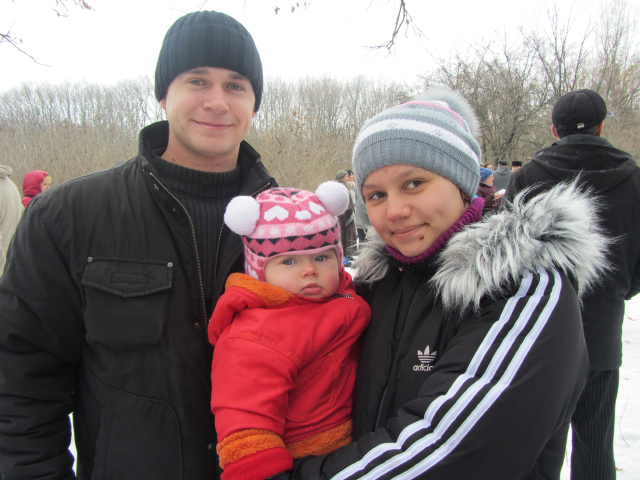 Олексій з дружиною Тетяною та донечкою Ксюшею вболівають за родичів, які прийшли позмагатися у ходьбі на лижах