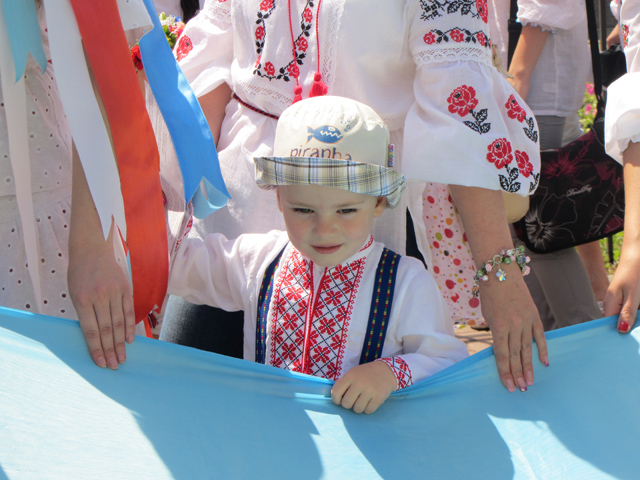Маленький полтавчик тримає розгорнутий прапор України