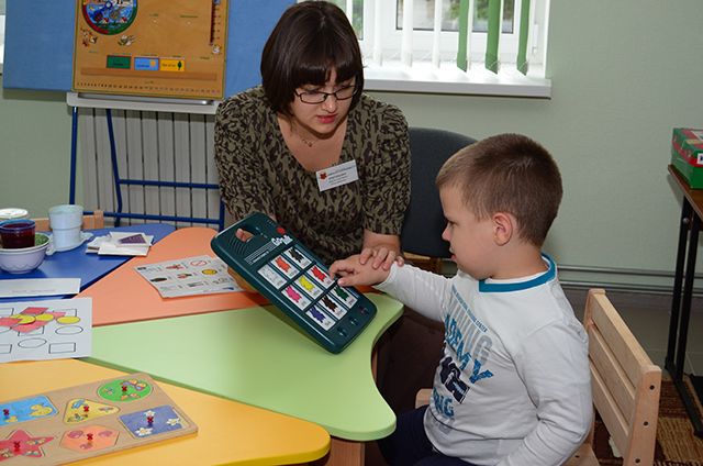 Учитель-реабилитолог Дарья Григорьева работает с ребенком по методу альтернативной коммуникации с помощью специального оборудования