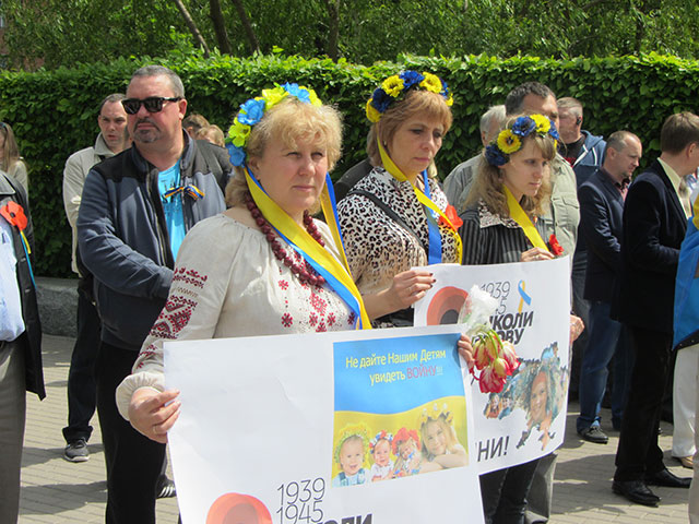 Жінки в українських вінках з плакатами