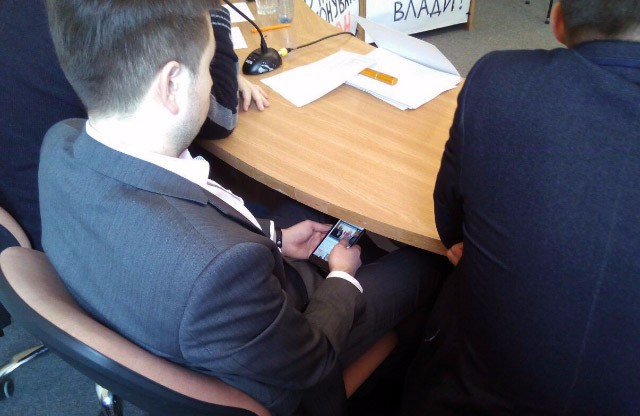 Депутат Іван Діденко читає трансляцію з засідання сесії