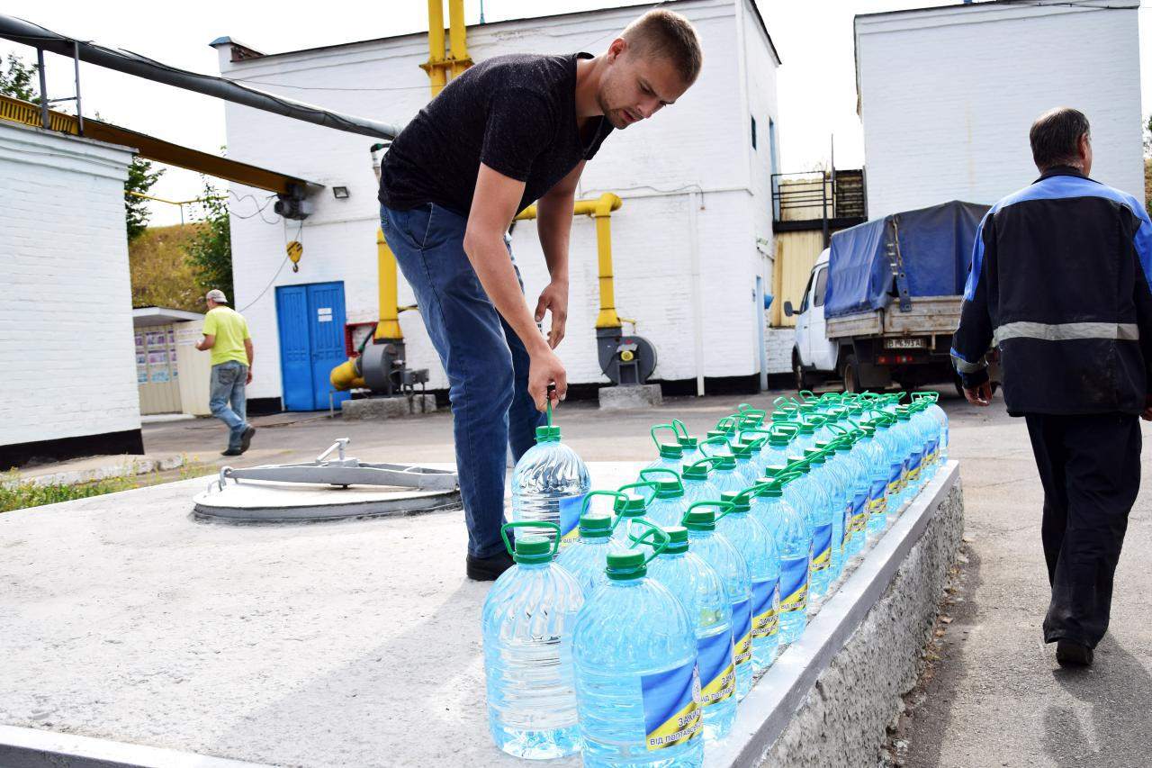 Працівники «Полтававодоканалу» вантажать воду в машину волонтерів