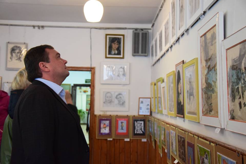 Андрій Пісоцький оглядає виставку картин у Вовчицькому музеї